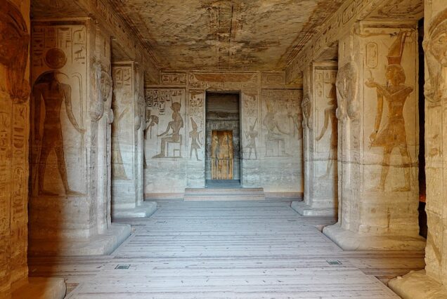 Interior of the Small Temple of Queen Nefertari at Abu Simbel, showing intricately carved pillars and walls with depictions of deities and Queen Nefertari.