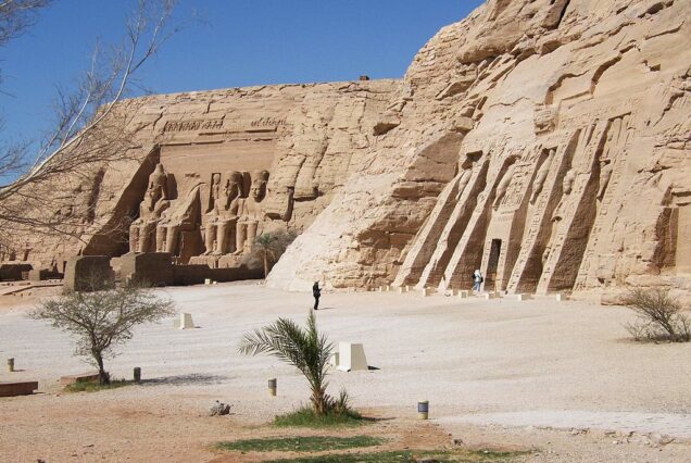 Facade of the Great Temple of Abu Simbel with four colossal seated statues of Ramesses II carved into the rock cliff.