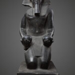 Statue of Pharaoh Thutmose III kneeling in worship, holding two Nu vases, wearing the Nemes headdress and uraeus.