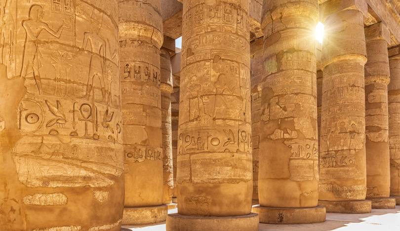 The Great Hypostyle Hall of Karnak Temple in Luxor, Egypt, featuring 134 massive sandstone columns adorned with hieroglyphs.