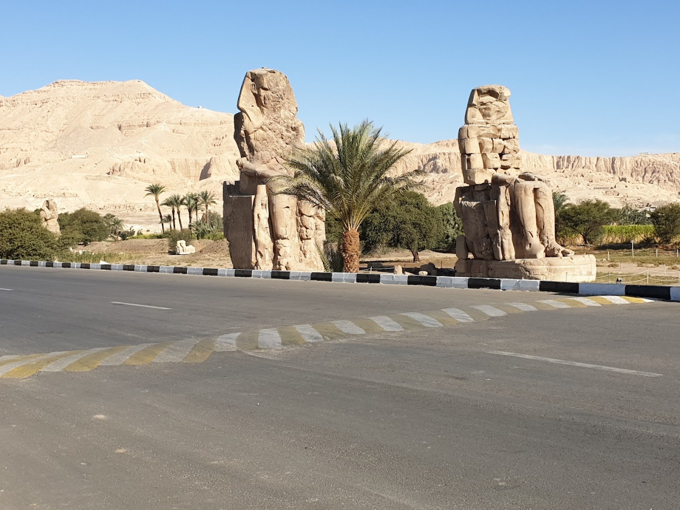 Two colossal stone statues of Pharaoh Amenhotep III seated on the west bank of the Nile near Luxor, Egypt.