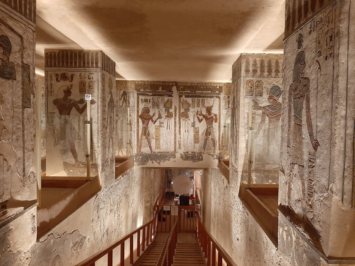 Interior of a decorated tomb in the Valley of the Kings, Luxor, featuring ancient Egyptian reliefs and hieroglyphs from the New Kingdom.