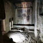 Interior of a rock-cut tomb at Qubbet el-Hawa necropolis in Aswan, Egypt, with ancient inscriptions and paintings