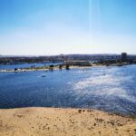Panoramic view of the Nile River in Aswan, Egypt, with the city and surrounding desert landscape