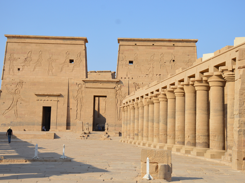 The Temple of Philae in Aswan, Egypt, showing its grand pylon adorned with ancient carvings, relocated to Agilkia Island to save it from Lake Nasser.