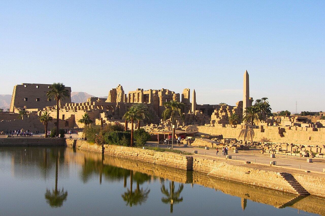 View of the Sacred Lake and surrounding monuments within the Precinct of Amun-Re at Karnak Temple, Luxor, Egypt.