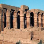 Interior hall of Luxor Temple with massive ancient Egyptian columns decorated with intricate carvings.