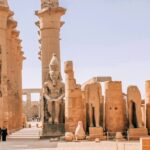 Luxor Temple on the east bank of the Nile River in Egypt, featuring colossal statues and ancient columns dedicated to the Theban Triad.