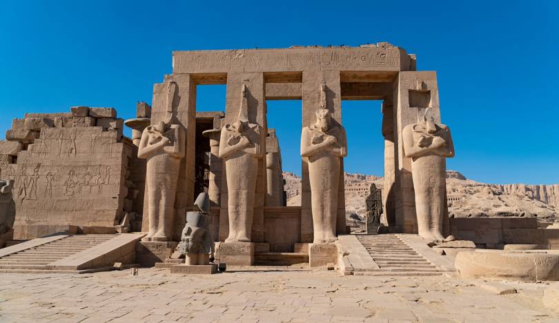 The Ramesseum mortuary temple of Pharaoh Ramesses II in Luxor, Egypt, featuring colossal statues and ancient ruins.