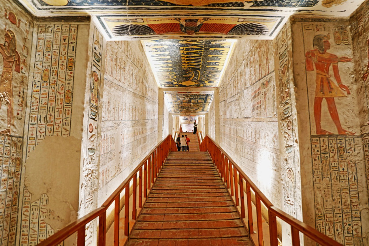 Interior of a tomb in the Valley of the Kings near Luxor, with colorful hieroglyphs and reliefs depicting ancient Egyptian funerary scenes.