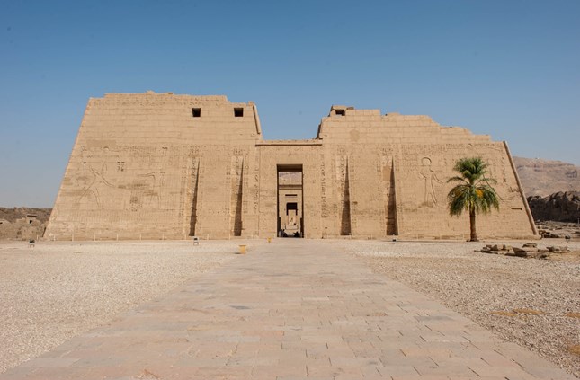 The Mortuary Temple of Ramesses III at Medinet Habu in Luxor, Egypt, showcasing massive columns, statues, and decorated walls.