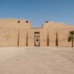 Mortuary Temple of Ramesses III at Medinet Habu in Luxor, Egypt, featuring colossal statues and detailed relief carvings.