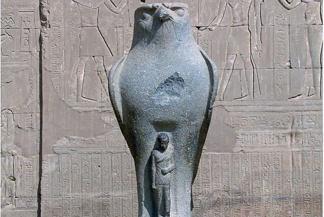 "Granite statue of the falcon-headed god Horus at the entrance pylons of the Temple of Edfu, Egypt."