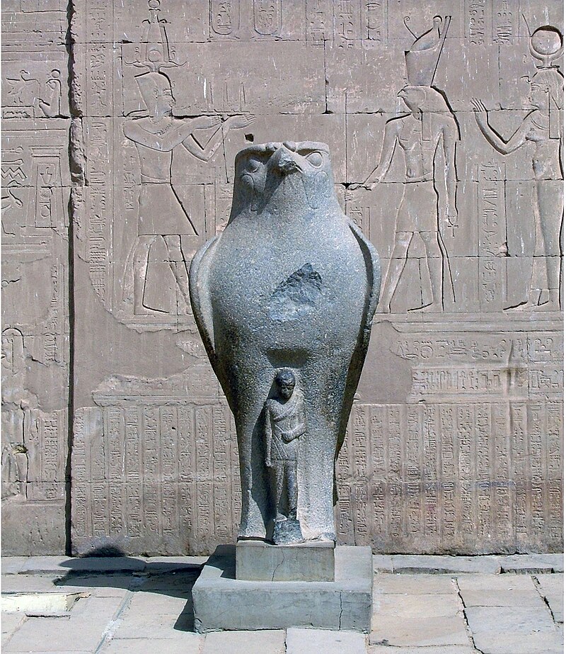 "Granite statue of the falcon-headed god Horus at the entrance pylons of the Temple of Edfu, Egypt."