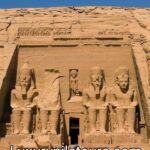 The Great Temple of Ramses II at Abu Simbel, featuring four colossal seated statues carved into a rock cliff in Nubia, Egypt.