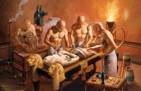 An ancient Egyptian scene depicting the mummification process, with priests and the Anubis deity overseeing the embalming of a body.