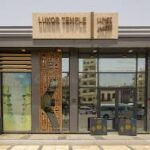 Entrance of Luxor Temple in Egypt, featuring monumental statues and ancient stone structures.