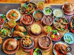 A variety of traditional Egyptian dishes including Ful, Koshary, Mahshii, and meat dishes served in bowls.
