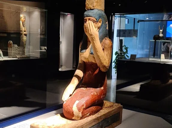 Painted wooden statue of the goddess Isis from the Ptolemaic period, depicted in mourning for her brother Osiris