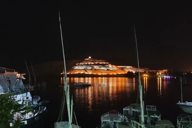 Nighttime view of the illuminated Tombs of the Nobles on the West Bank of the Nile in Aswan, Egypt.