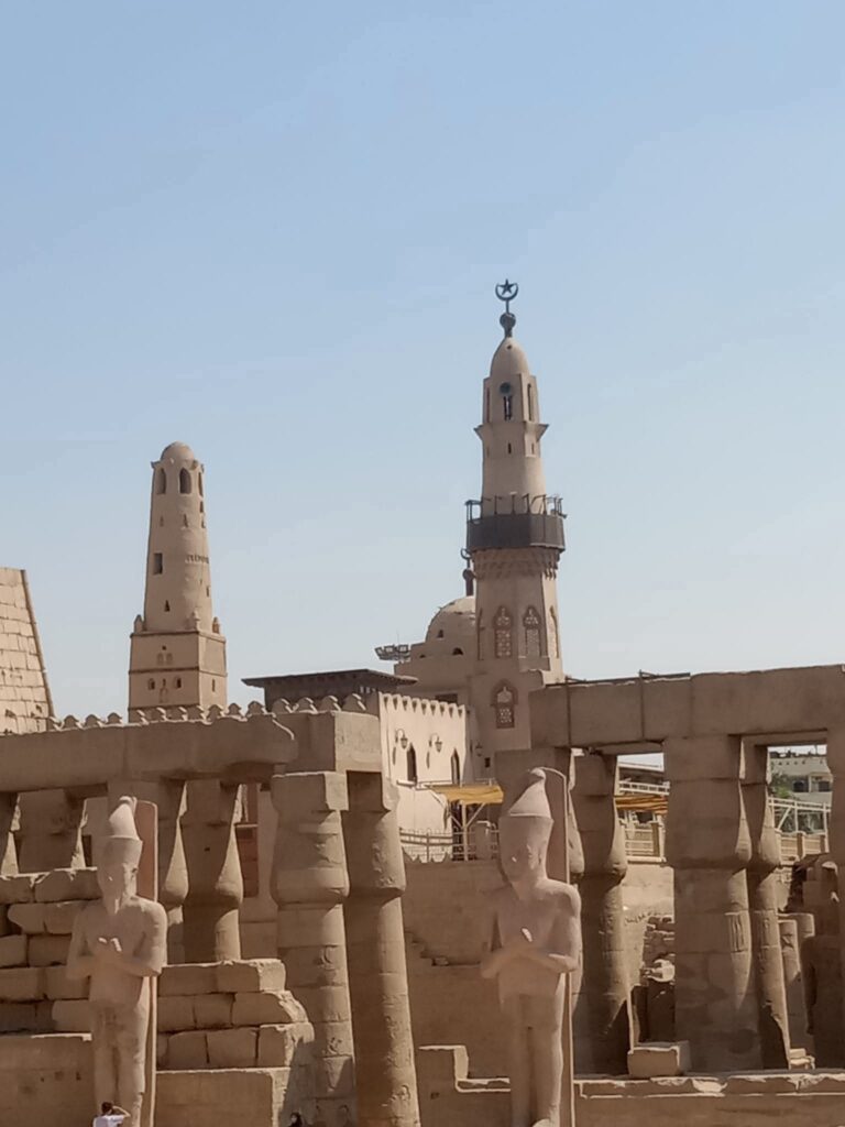 "The Abu El-Hagag Mosque built within the Luxor Temple complex in Egypt, standing above ancient columns and ruins."