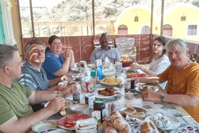 Group of people sitting together and enjoying a meal at the Nubian Guesthouse.