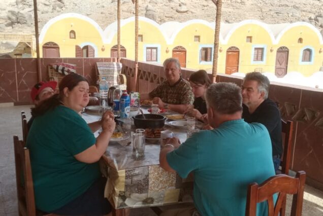 Group of people sitting together and enjoying a meal at the Nubian Guesthouse.