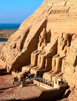 The façade of the Great Temple of Abu Simbel with four colossal seated statues of Ramesses II carved into the cliff.